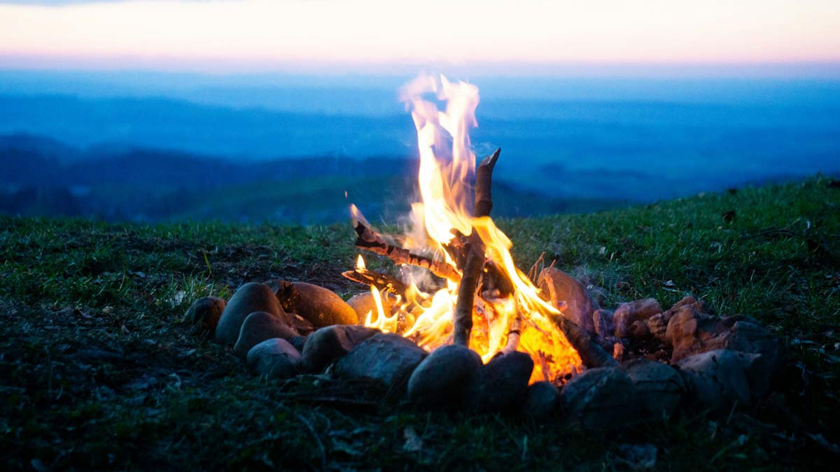 Bild von einem Feuer in der Abenddämmerung mit weitem Horizont dahinter